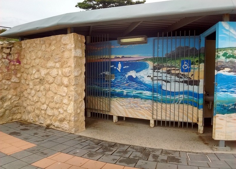Women's public toilets show a female with surfboard at Middleton Beach in South Australia.